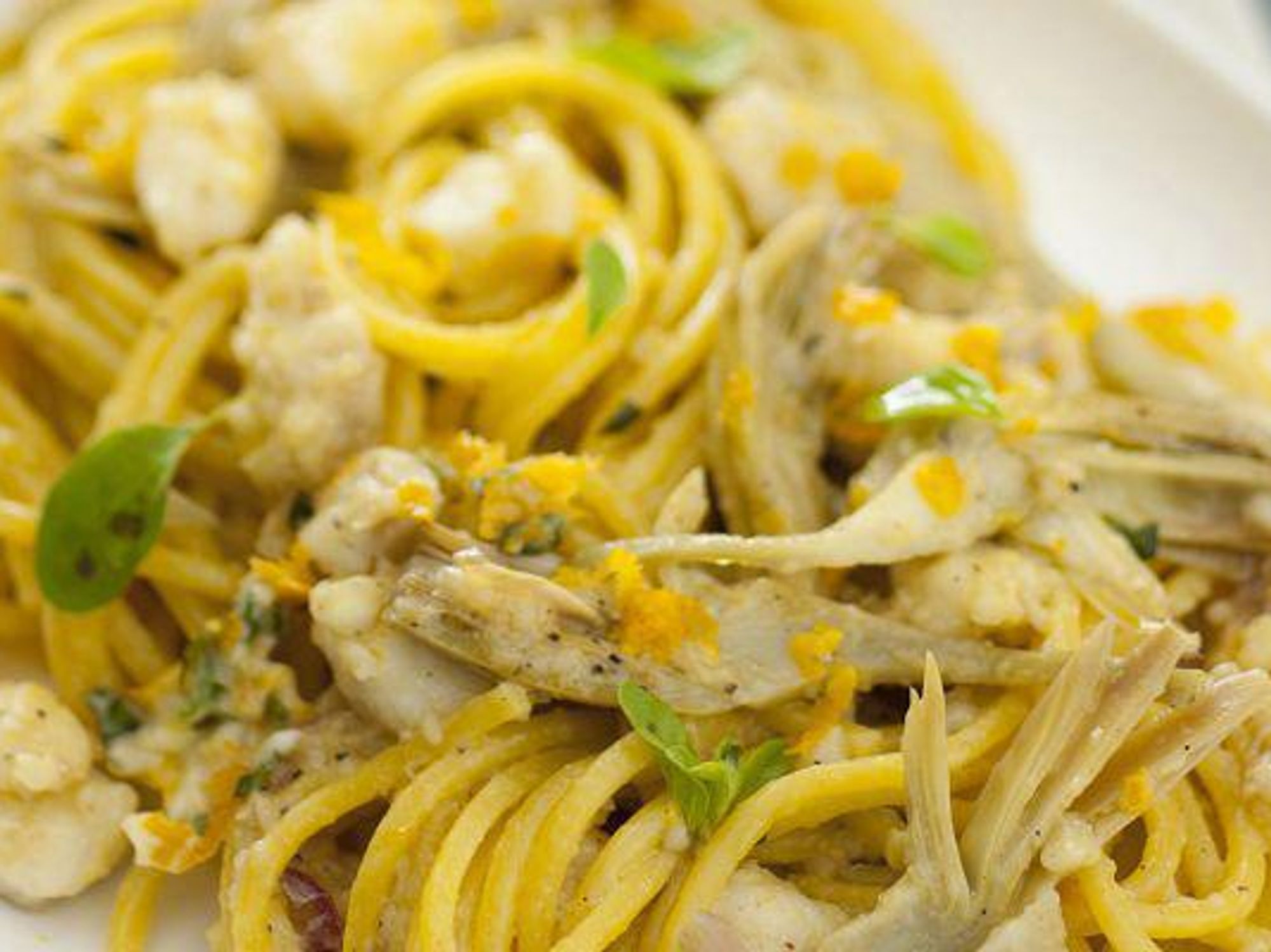 Spaghetti with white fish sauce and artichokes