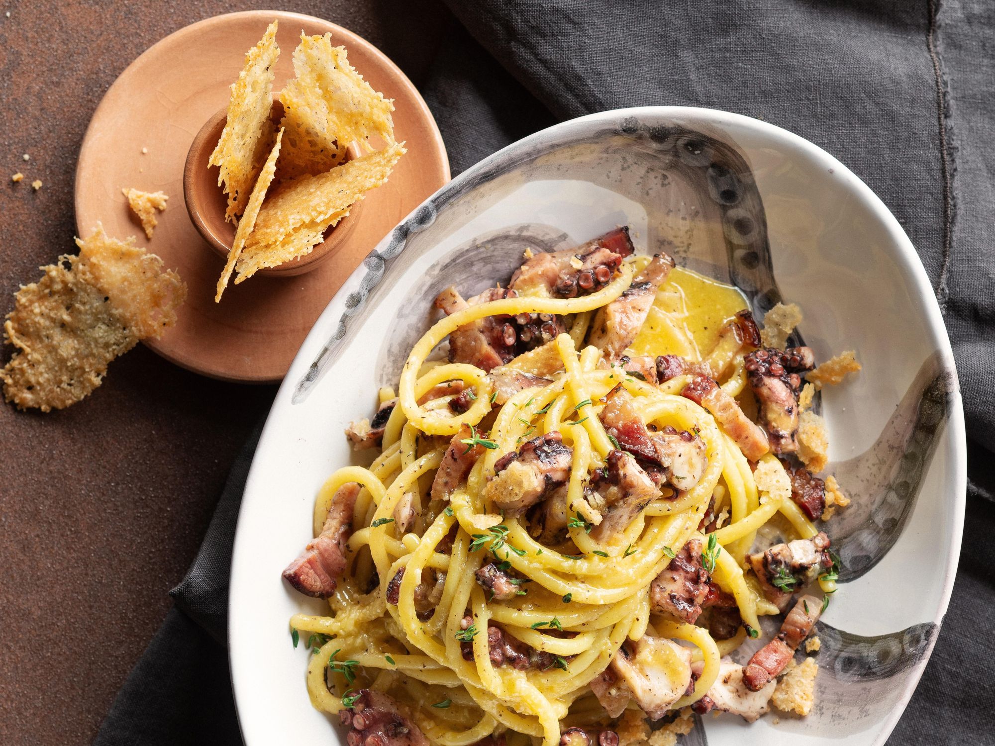 Carbonara spaghettoni with octopus, bacon, and cheese chips
